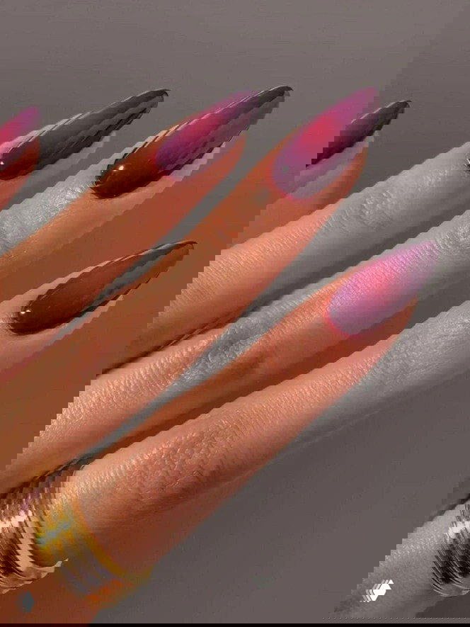 Омбре-маникюр в пурпурно-бордовой гамме на длинных миндалевидных ногтях, детализированный крупный план с акцентом на градиенте цвета.