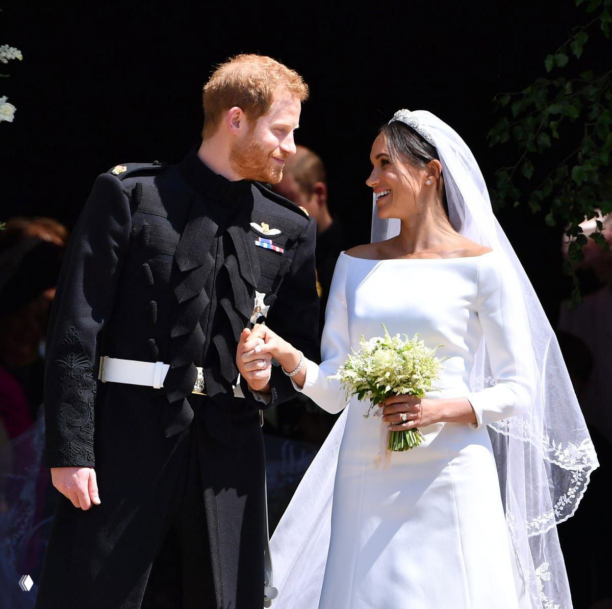 Молодожёны в свадебной одежде выходят после церемонии, держатся за руки и улыбаются — фотография передаёт праздничную атмосферу торжества и радости.