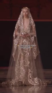 Модель в роскошном расшитом серебристом платье Elie Saab с прозрачной вуалью и обильно сияющей отделкой, кадр с подиума haute couture.