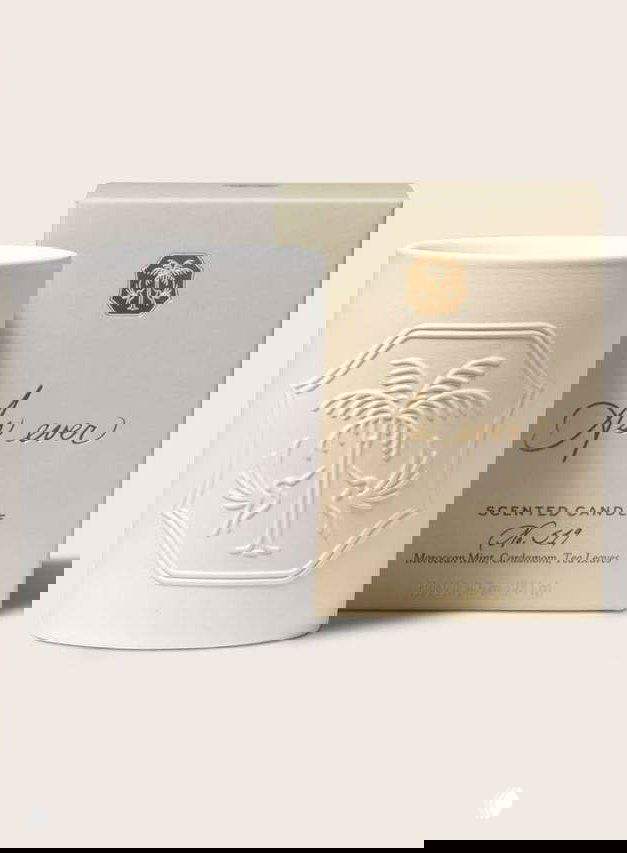 Кремовая керамическая ароматическая свеча рядом с коробкой с тиснёным логотипом и надписью; товарная фотография демонстрирует упаковку и дизайн продукта.
