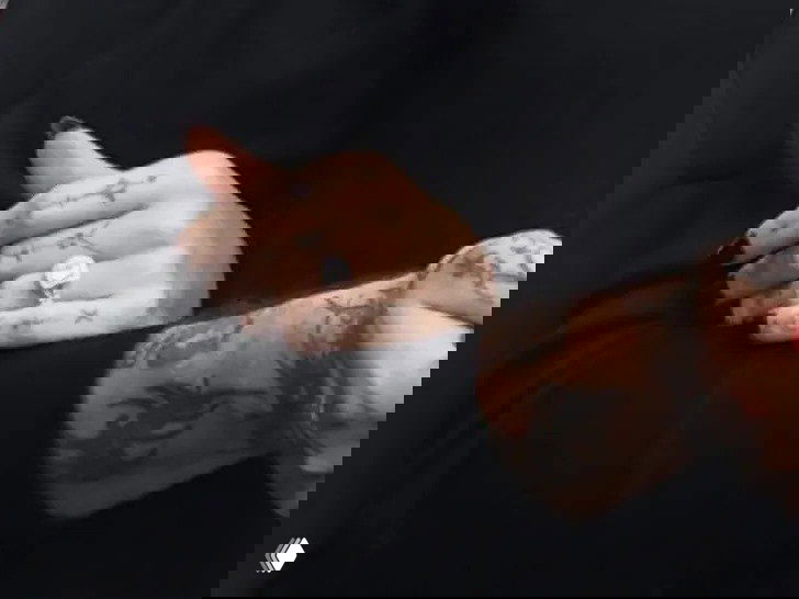 Крупный план рук с обручальным кольцом и татуировками на пальцах Дав Кэмерон и Дамиано Давида, кадр папарацци