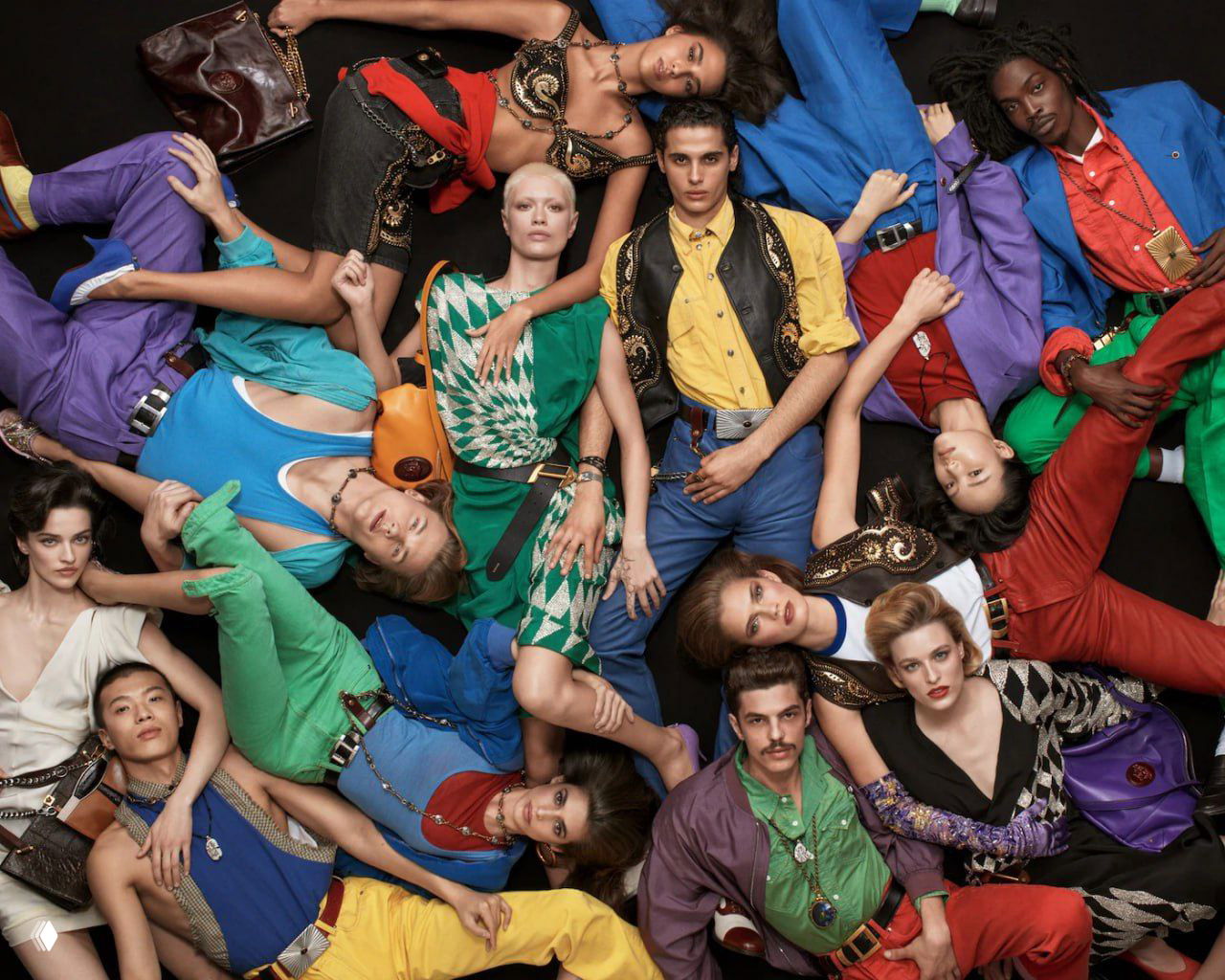 Групповой портрет моделей в ярких образах Versace: динамичная укладка, смелые цвета и фирменные украшения бренда на чёрном фоне.