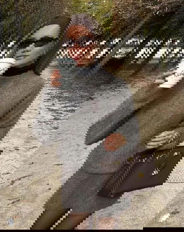 Портрет в уличном парке: образ с серой водолазкой и мини-юбкой, сумка-тоут и солнцезащитные очки создают непринуждённый стиль.