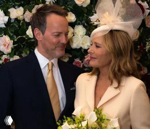 Невеста в белом костюме с жакетом и фатиновой юбкой, в шляпке и перчатках, рядом жених в тёмном костюме — праздничный портрет со свадьбы.