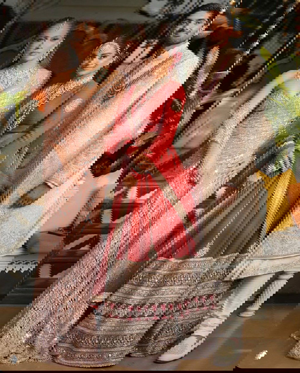 Групповое фото: Дженнифер Лопес позирует вместе с молодожёнами — невестой Нетрой Мантеной и женихом, все в традиционных праздничных нарядах.