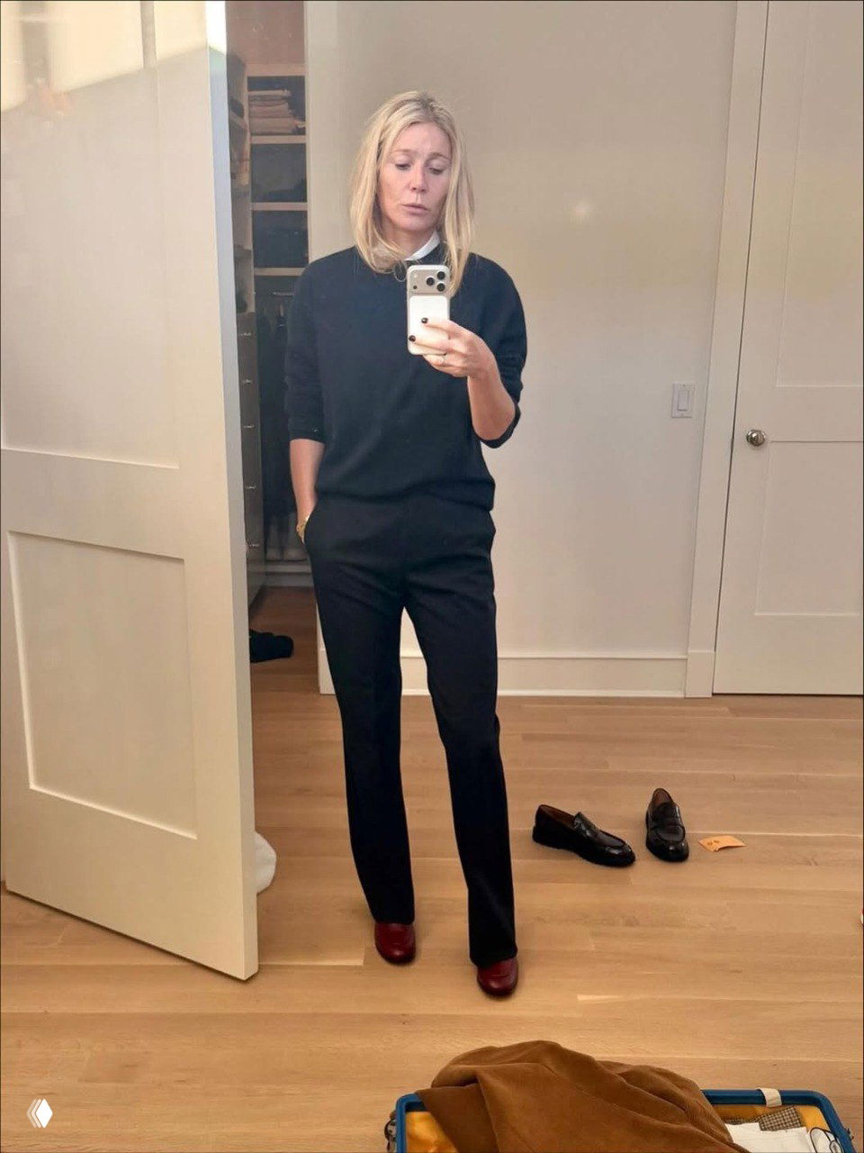 Гвинет Пэлтроу в тёмном комплекте свитер и брюки делает селфи в прихожей, лаконичный офисный образ из новой коллекции Gwyn