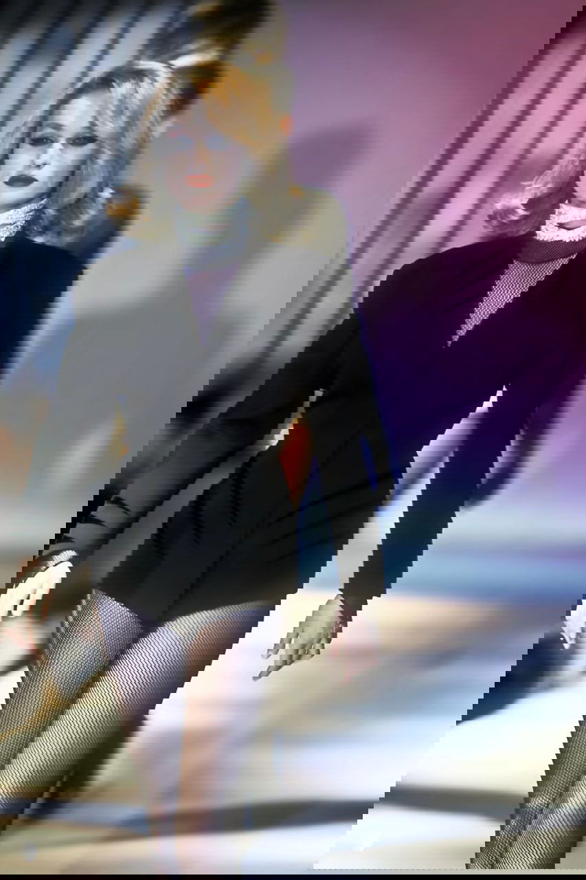 Модель в коротком чёрном жакете, сетчатых колготках и выразичным макияжем — ретро-эстетика осенней коллекции Mugler 1990 на подиуме.