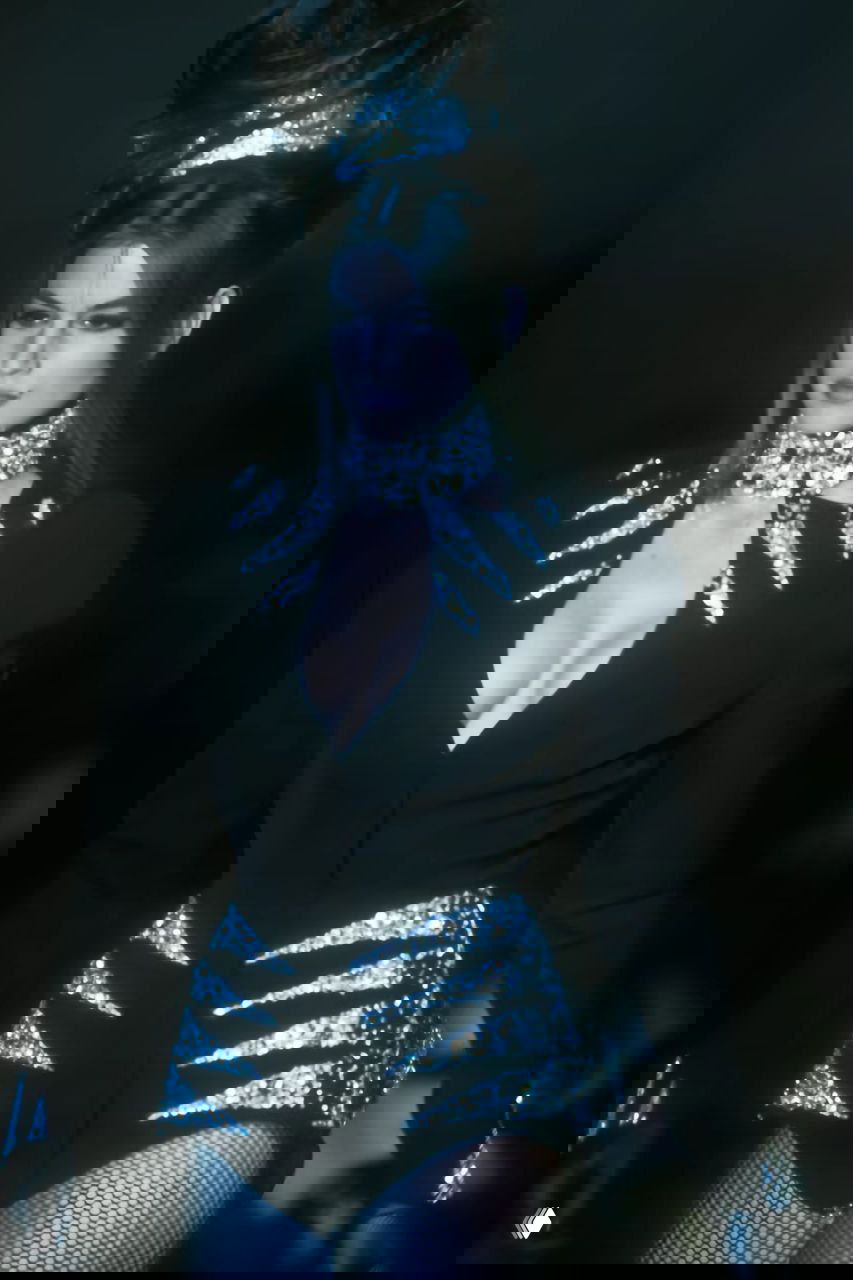 Крупный план модели с высоким украшенным воротником и строгим силуэтом — декоративные элементы и вечерняя стилистика в коллекции Mugler 1990.