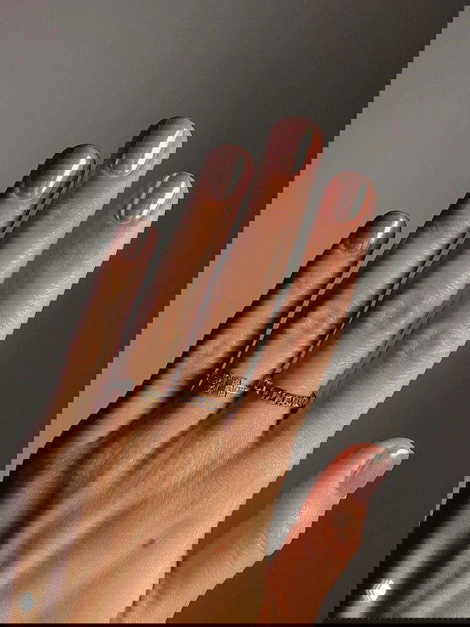 Длинные пальцы с коротким естественным маникюром в нюдово-коричневой полупрозрачной гамме и тонким блеском на поверхности — спокойный зимний дизайн.