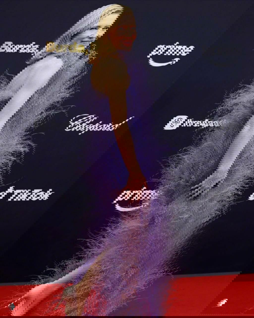 Профильный портрет Кейт Бланшетт в длинном фиолетовом платье со струящимися растительными перьями на красной дорожке Bambi Awards.