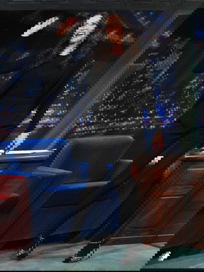 Знаменитость в черном образе на телеэфире в высоких черных туфлях с блестящими деталями — вариант для вечернего выхода и праздника.