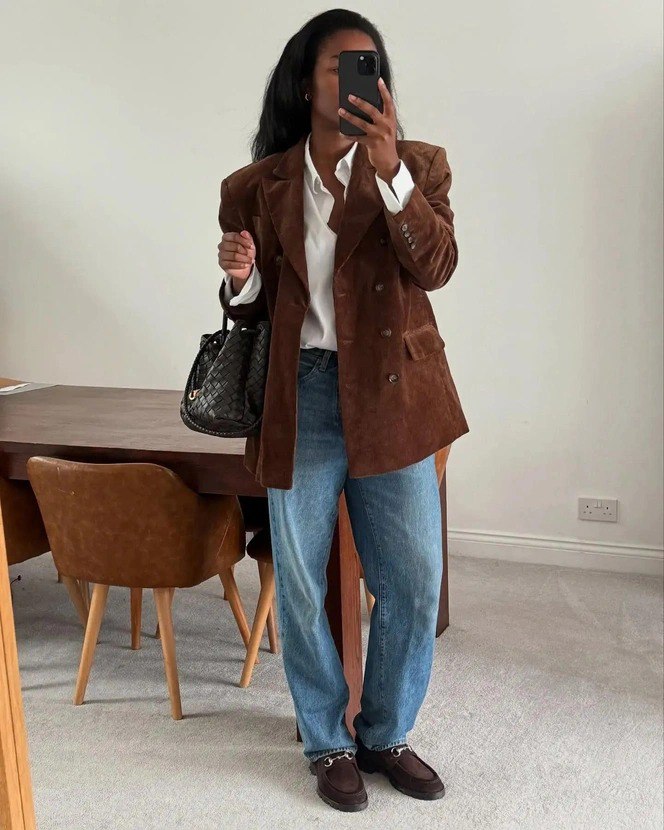 Селфи в зеркале: коричневый бархатный пиджак поверх белой рубашки и свободные голубые джинсы — пример многослойного smart casual.