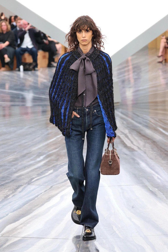 Модель в тёмно‑синих прямых джинсах и тёмно‑синем трикотажном накидке с яркими акцентами синего, демонстрация классического денима.