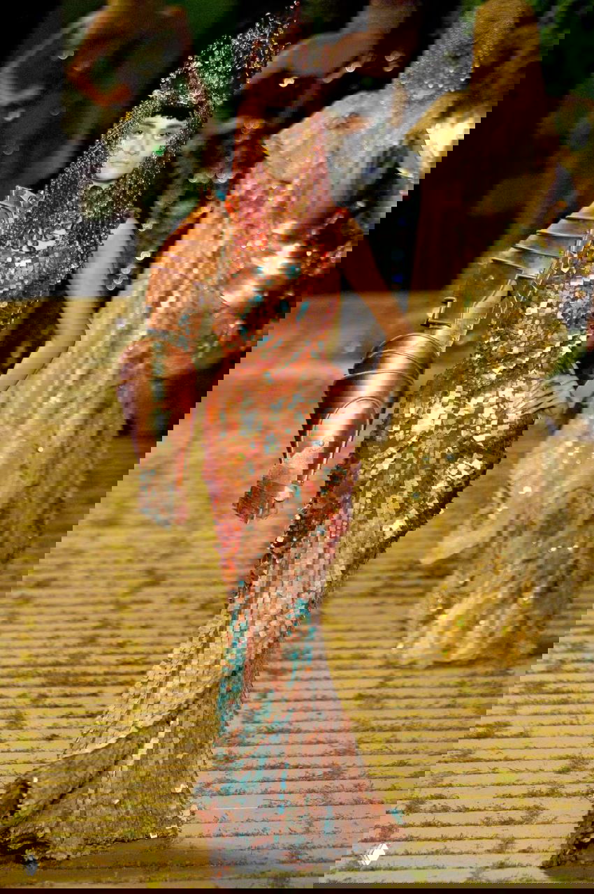 Модель на подиуме в образе Dior couture 2006: бронзовое платье из больших пайеток и массивная металлическая наплечная деталь, режиссерская подиумная атмосфера.