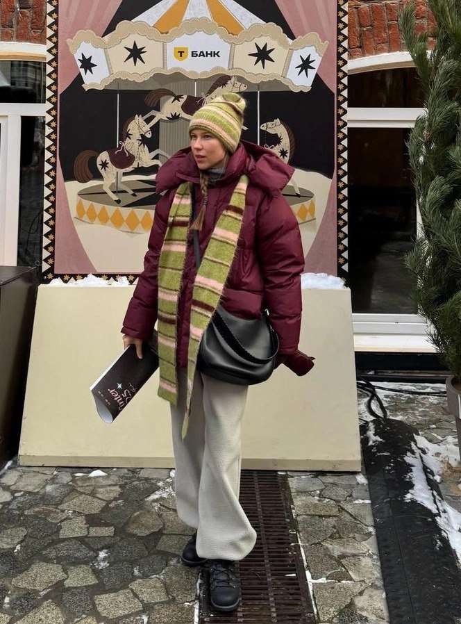 Вязаная шапка и полосатый шарф в комплекте с тёплой курткой: уличный зимний лук с объёмными слоями и уютной текстурой аксессуаров.