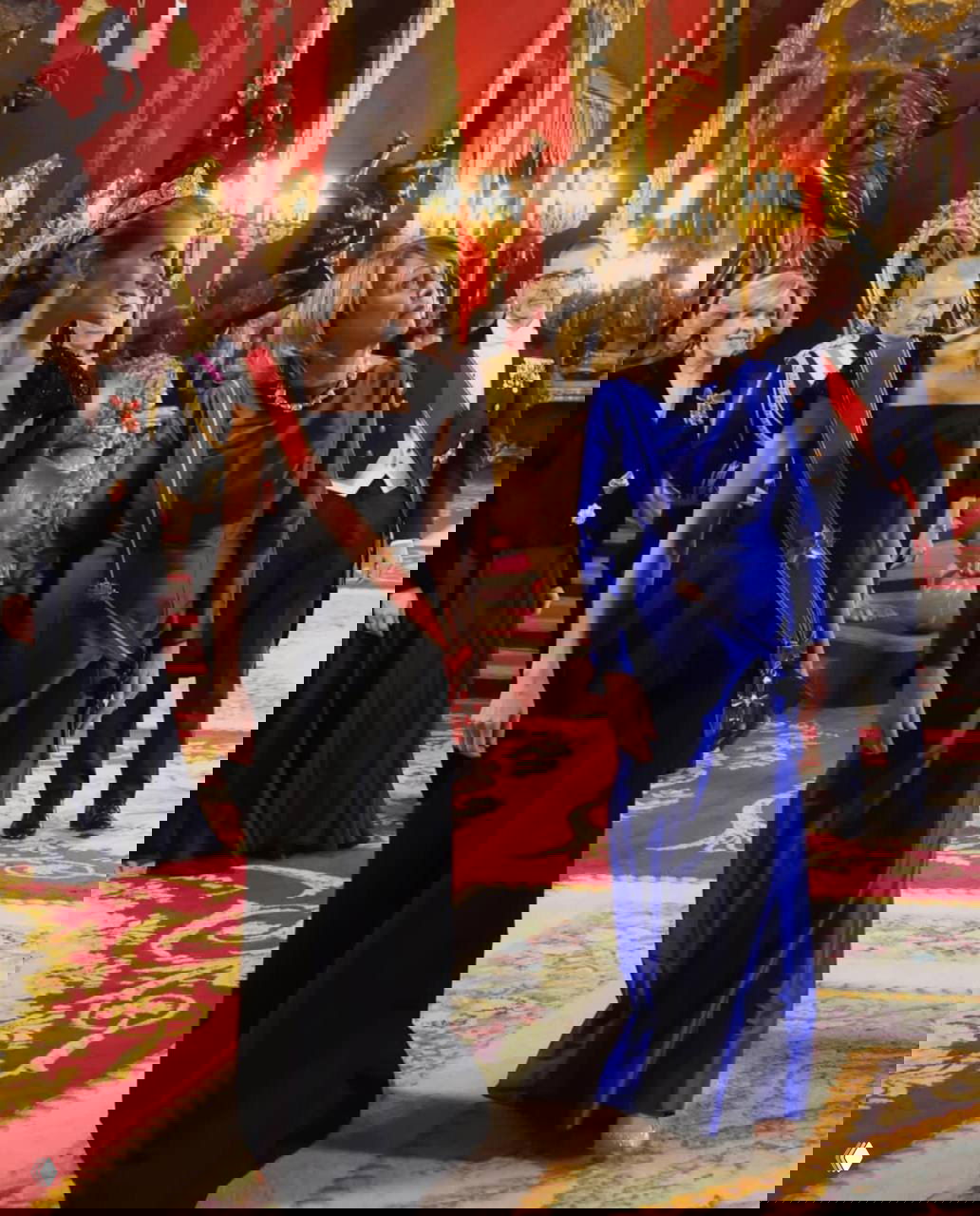 Королева Летиция и первая леди Германии Эльке Бюденбендер идут по ковру в парадных залах дворца, гости сопровождают их во время официальной части программы.