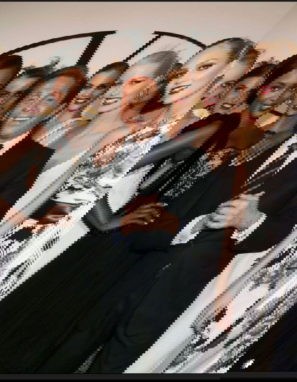 Групповая фотография моделей в вечерних нарядах, в центре стоит мужчина в костюме; праздничный кадр после показа.