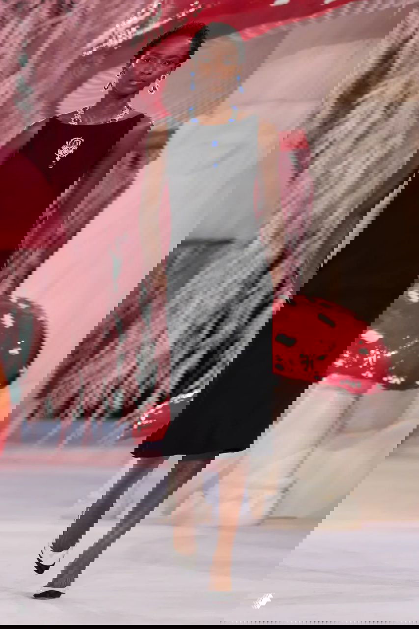 Чёрное приталенное платье и крупные ювелирные украшения на шее — строгий контраст пастельному лесному оформлению показа Chanel.