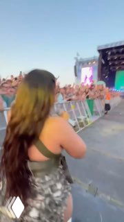 Короткое видео: зрительница у ограждения снимает выступление Нелли Фуртадо сзади; видно сцену, толпу и летнюю фестивальную атмосферу.