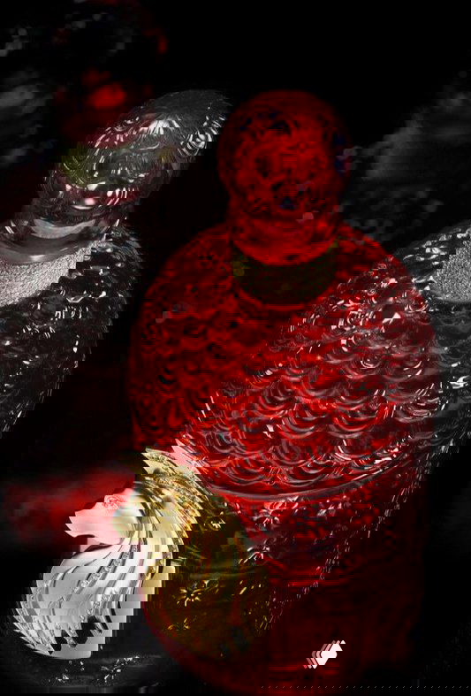 Красный флакон Rouge Voluptueux от Guerlain с узорным стеклом, золотая фигурка лошади и инкрустация кристаллами Swarovski.