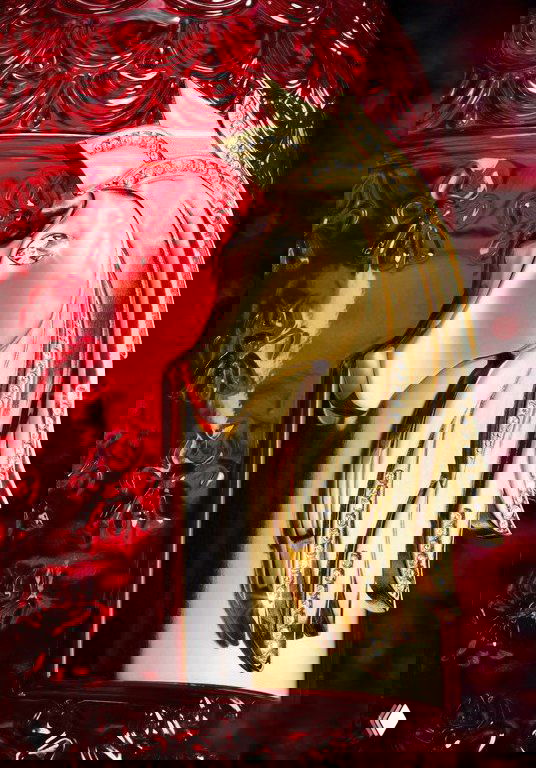 Крупный план золотой фигурки лошади на флаконе Rouge Voluptueux: ювелирная деталь с гривой и инкрустацией кристаллами.