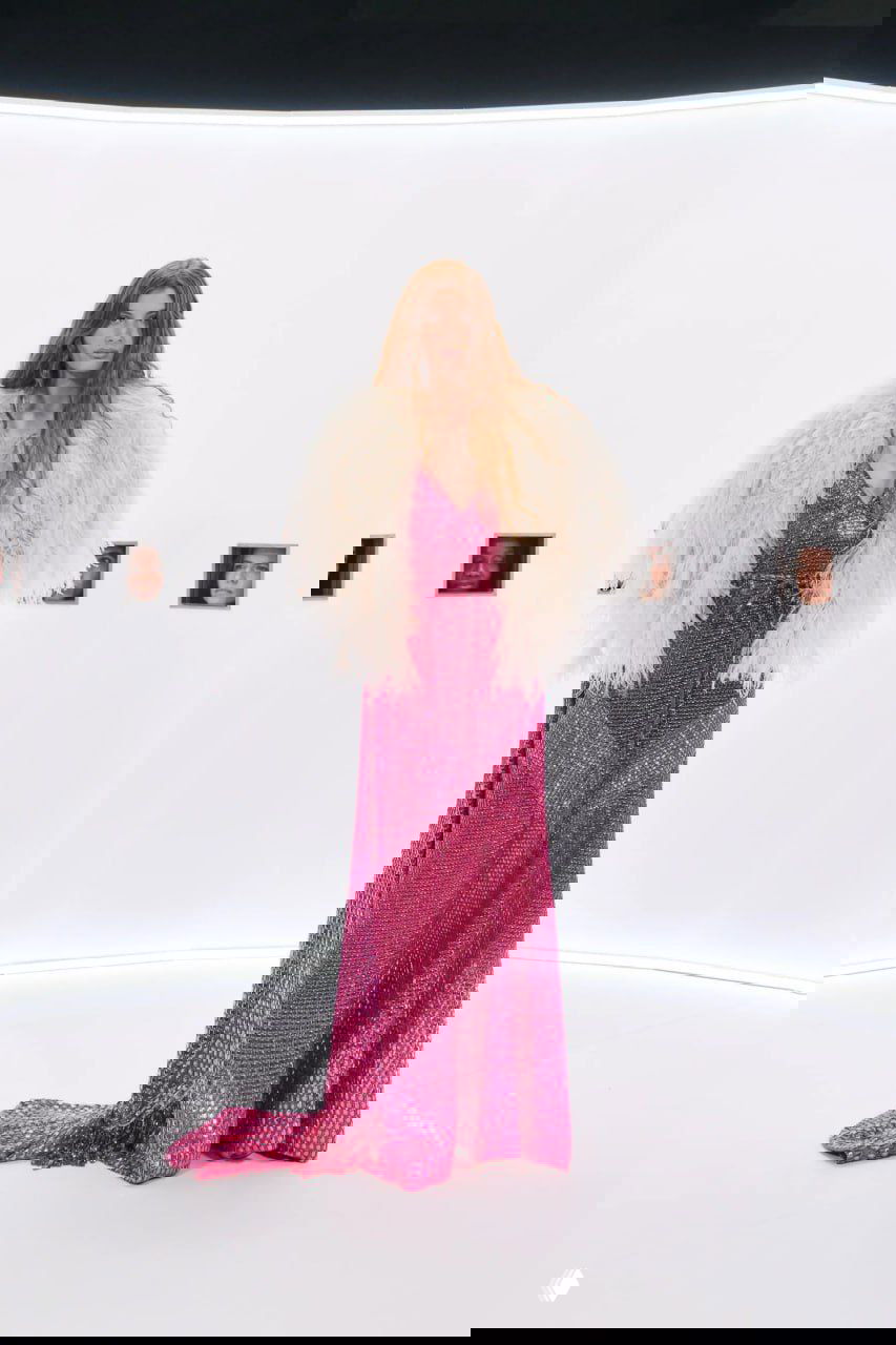 Длинное розовое платье с блёстками и корсетной линией в минималистичном окружении шоу — модели размещены в круглом белом пространстве.