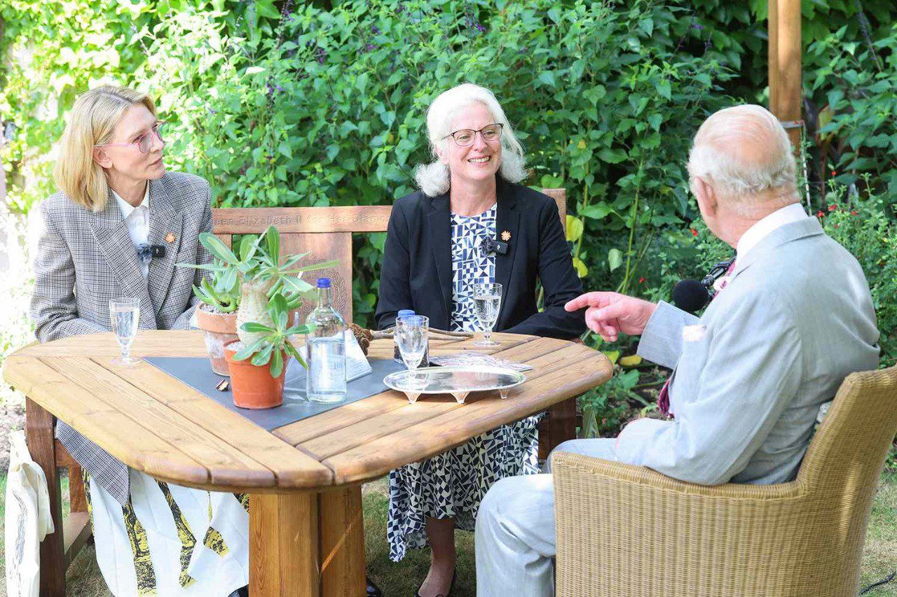 Кейт Бланшетт, доктор Элинор Бреман и король Карл III сидят за столом в саду во время записи подкаста о сохранении семян редких растений.