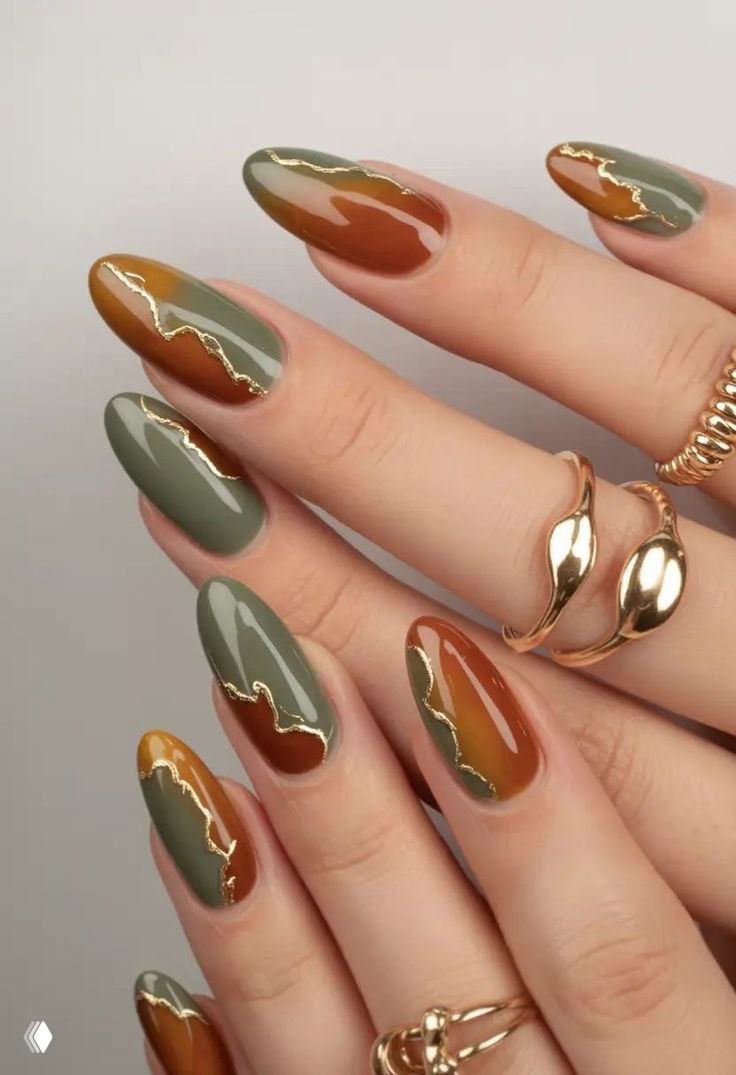 Крупный план рук с овальными ногтями в оливково‑коричневых оттенках и тонкой декоративной золотой «трешинкой», глянцевый финиш и кольца