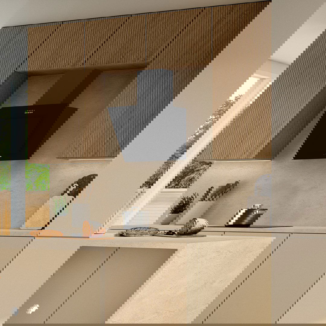 Кухонная сцена в нейтральных тонах: черная наклонная вытяжка Gorenje над варочной панелью, на столешнице хлеб и кастрюля.