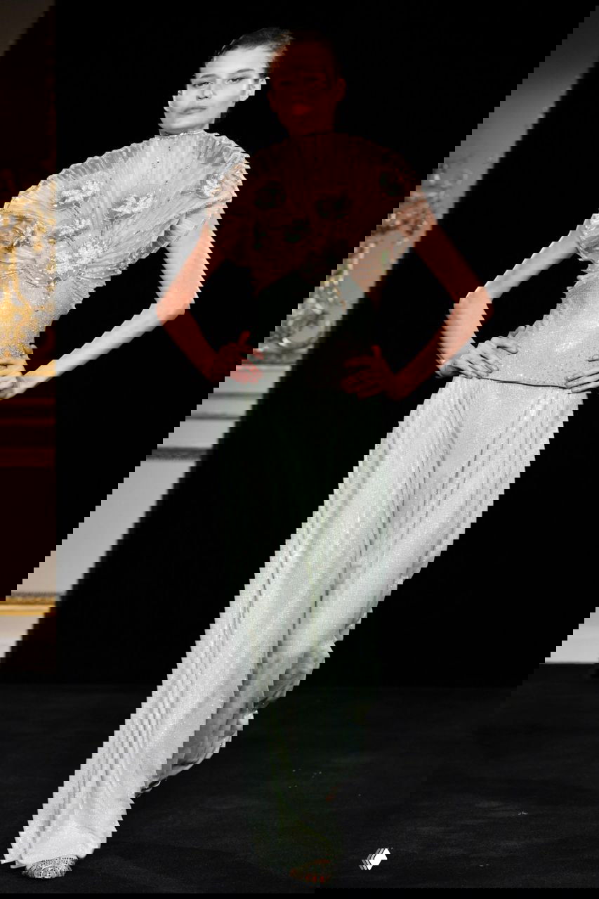 Модель в светло-мятном платье с рельефной отделкой по лифу и тонкой драпировкой, подиум Giorgio Armani подчёркивает пастельную гамму и текстуры ткани.