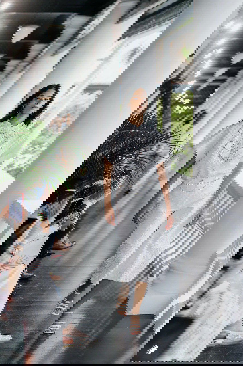 Белая льняная блуза и широкие кюлоты, цепной пояс и пляжная атмосфера — лёгкий дневной образ из круизной коллекции Chanel на колоннаде отеля.