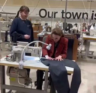 Кейт пробует шить джинсы за швейной машиной в мастерской Melin Tregwynt; вокруг видны ткани, инструменты и рабочие пространства мастерской