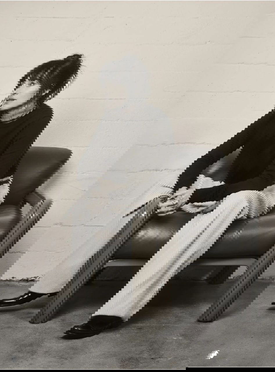 Монохромная фотография актрисы в спокойной позе на кресле; съёмка подчёркивает силуэт, текстуры и минималистичный реквизит.