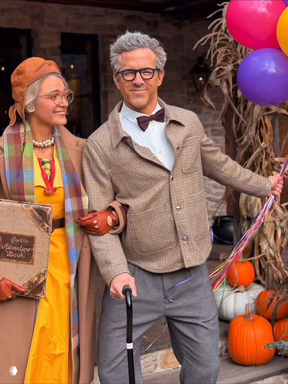 Пара идёт по осенней улице в образах из «Вверх!»: он опирается на трость и держит яркие шарики, вокруг сезонный декор и тыквы.