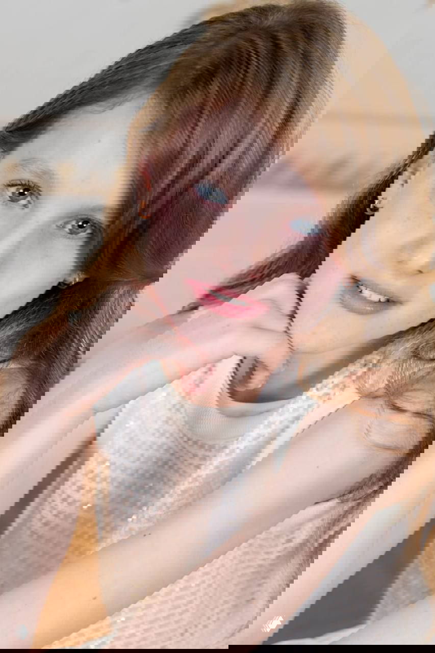 Официальный портрет принцессы Монако Габриэллы, 11 лет: крупный план лица и плеч, светлое платье и нейтральный фон, торжественная атмосфера.