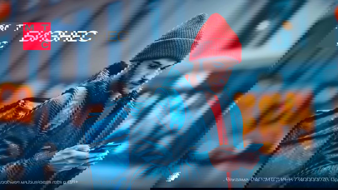 Курьер в красной шапке с большим рюкзаком на городской улице смотрит в смартфон — иллюстрация кейса про велошеринг и проблемы GPS