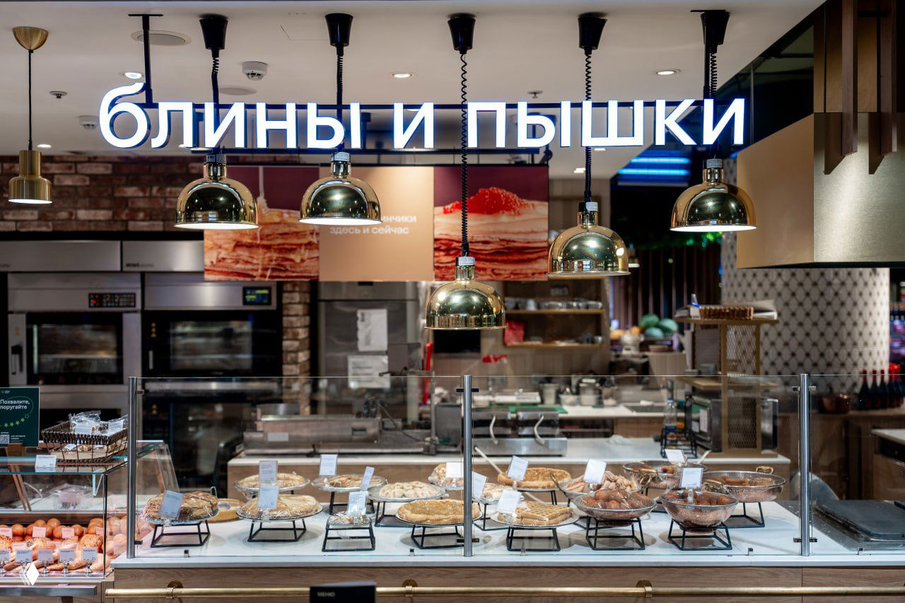Теплая зона «блины и пышки» и кондитерская витрина в магазине «Азбука вкуса», демонстрация собственной выпечки, где проходят дегустации и свежая подача