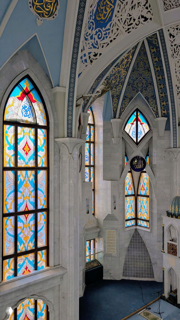 Вертикальный вид витражных окон и купольных арок мечети Кул Шариф — голубо-золотой орнамент и мягкое дневное освещение внутри.