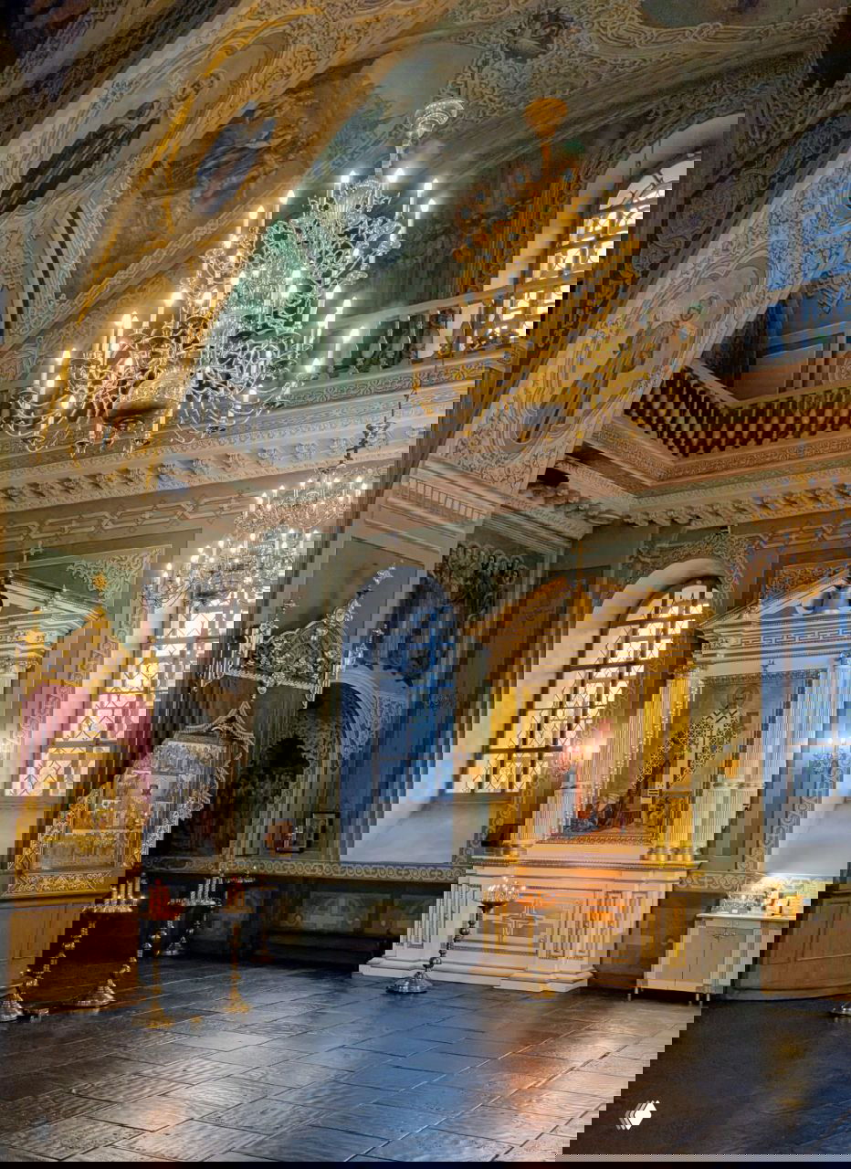 Интерьер Благовещенского собора: люстры, настенные росписи и иконостас в мягком свете — спокойная церковная атмосфера внутри кремля.