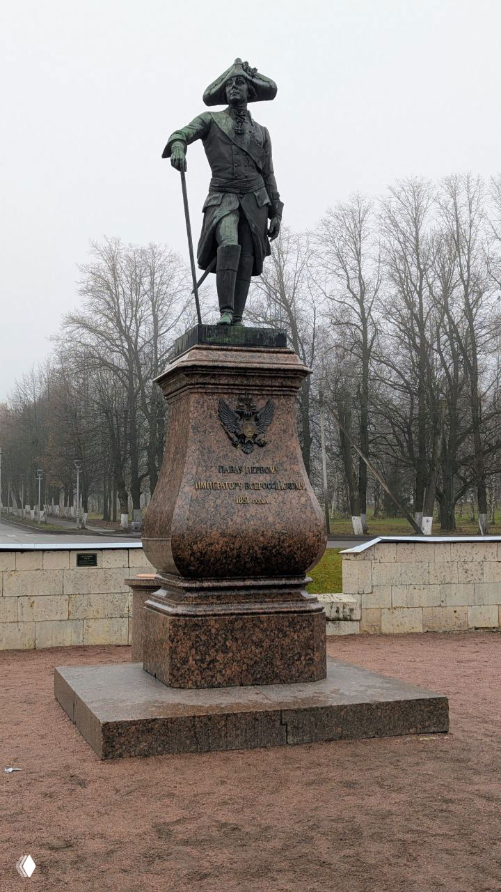 Памятник Павлу Первому у Гатчинского дворца на гранитном постаменте на фоне голых деревьев и пасмурного неба, общий план.