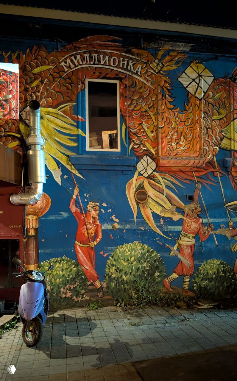 Яркая настенная роспись с надписью «Миллионка» и изображениями в фольклорном стиле — уличное искусство и фасад ресторана во Владивостоке