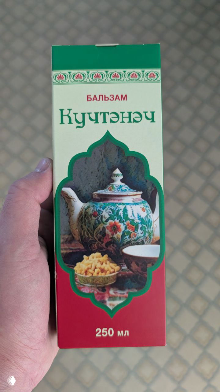 Упаковка татарского бальзама «Кучтэнач» 250 мл в руке автора — традиционный напиток и сувенир из Казани.