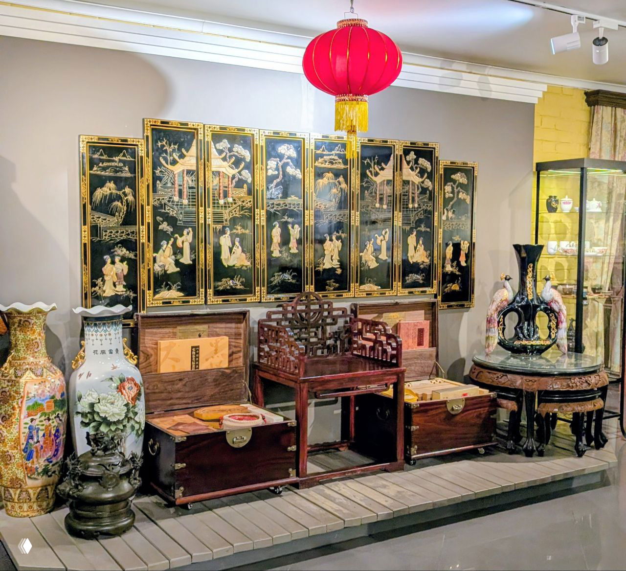 Экспозиция с китайскими ширмами, шкафами и сундуками: декоративные панели, вазы и мебель в стиле восточной комнаты в музее