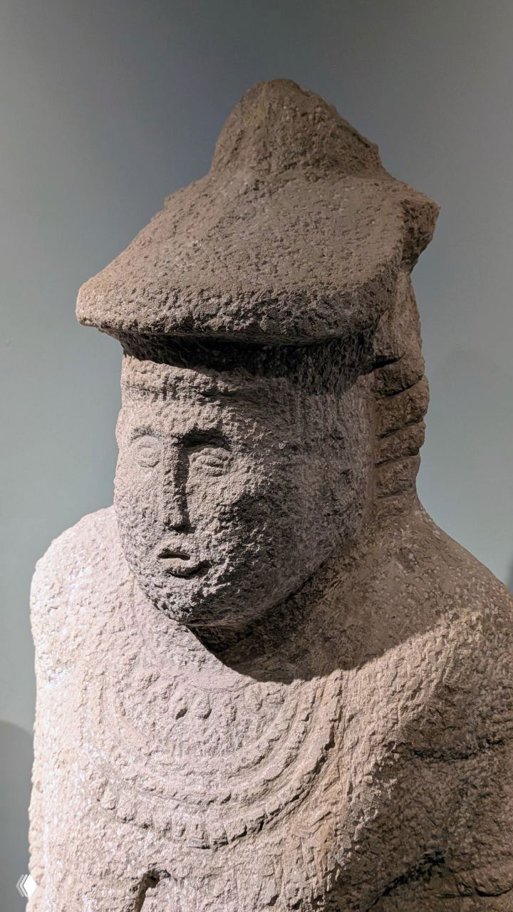 Каменная антропоморфная статуэтка или изваяние древнего тюркского периода с видимыми следами эрозии, выставленное в экспозиции музея.