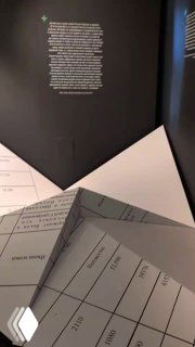 Музейная витрина с бумажными документами, таблицами и текстовой информацией экспозиции — архивный материал в экспозиционном оформлении.