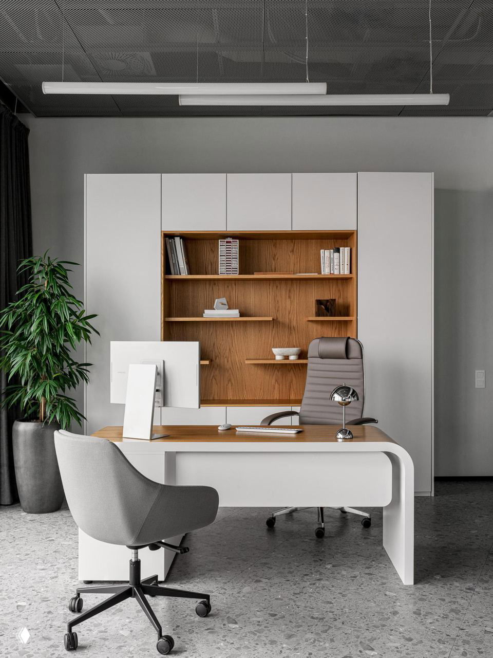 Кабинет руководителя: белый стол с деревянной столешницей, книжный шкаф с деревянной отделкой, кресло и зелёное растение рядом в офисе 2ГИС в Москве.
