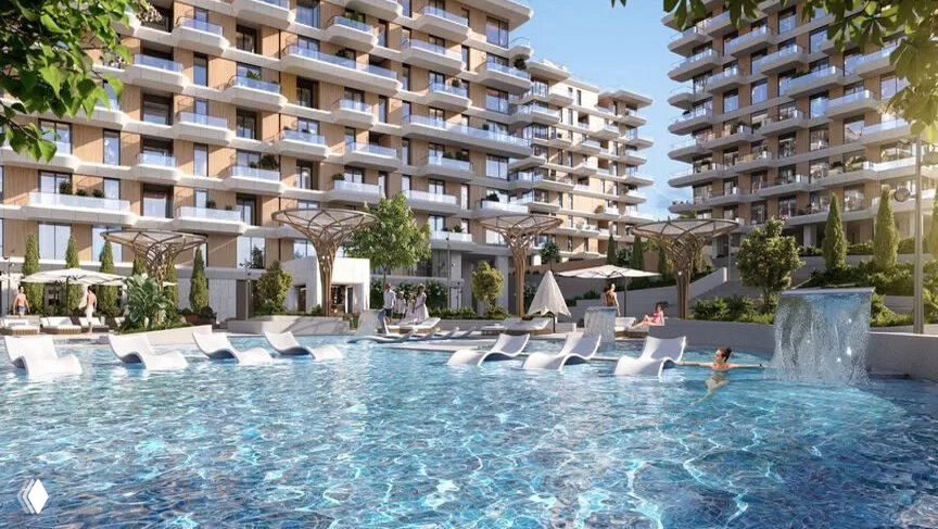 Панорамный бассейн на территории современного жилого комплекса в Ялте на берегу моря с шезлонгами и многоэтажными корпусами вокруг