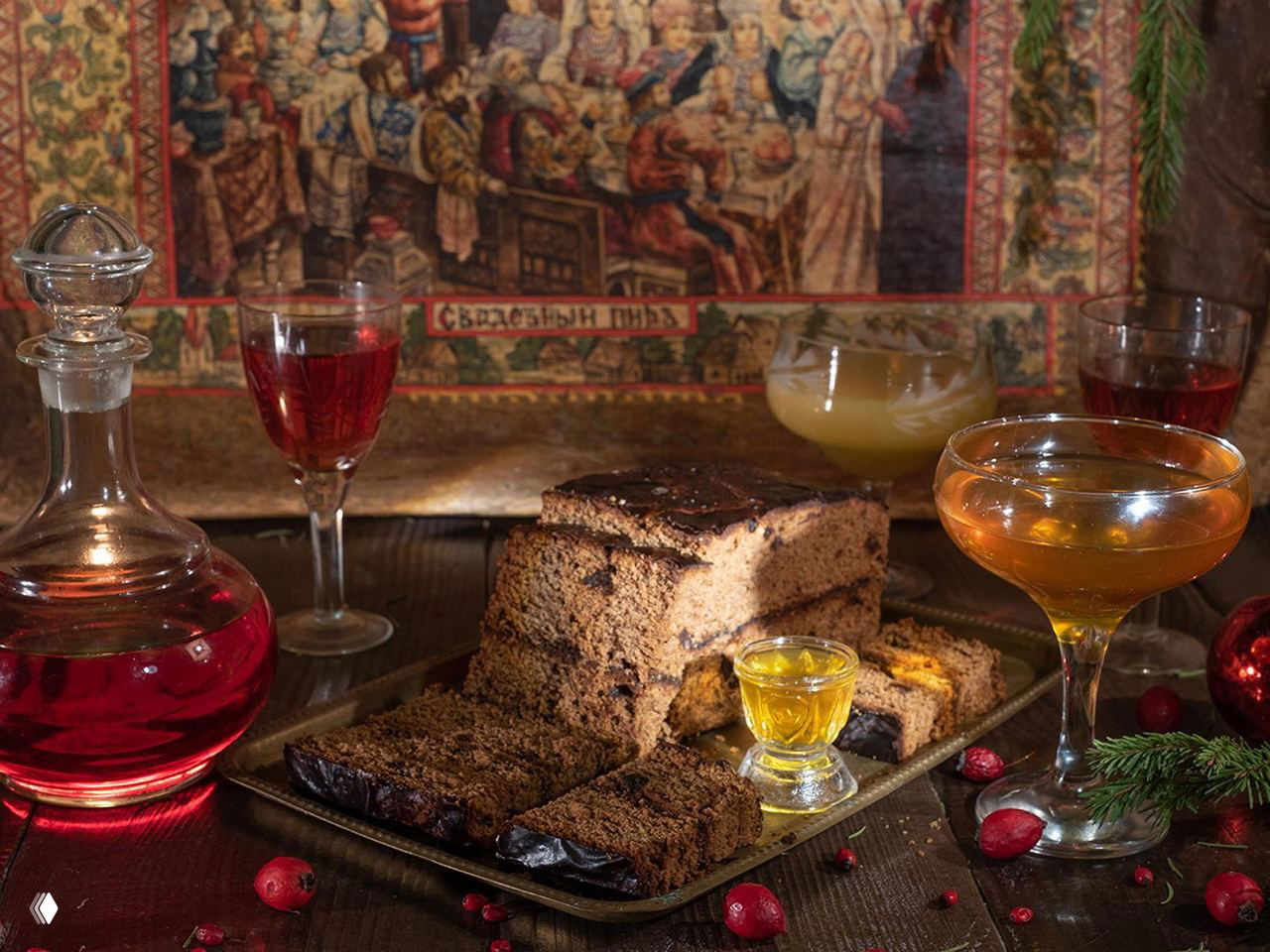 Близкий план традиционных русских сладостей и напитков на столе: куски пастилы или кекса, рюмки и графин на фоне декоративной ткани.