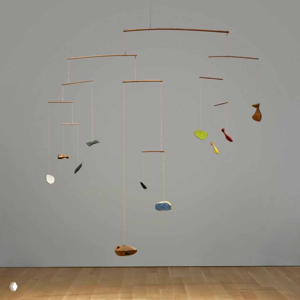 Вид мобиля Колдера почти в натуральную величину: нижние элементы висят близко к паркету, композиция читается на фоне светлого пола и нейтральной стены.