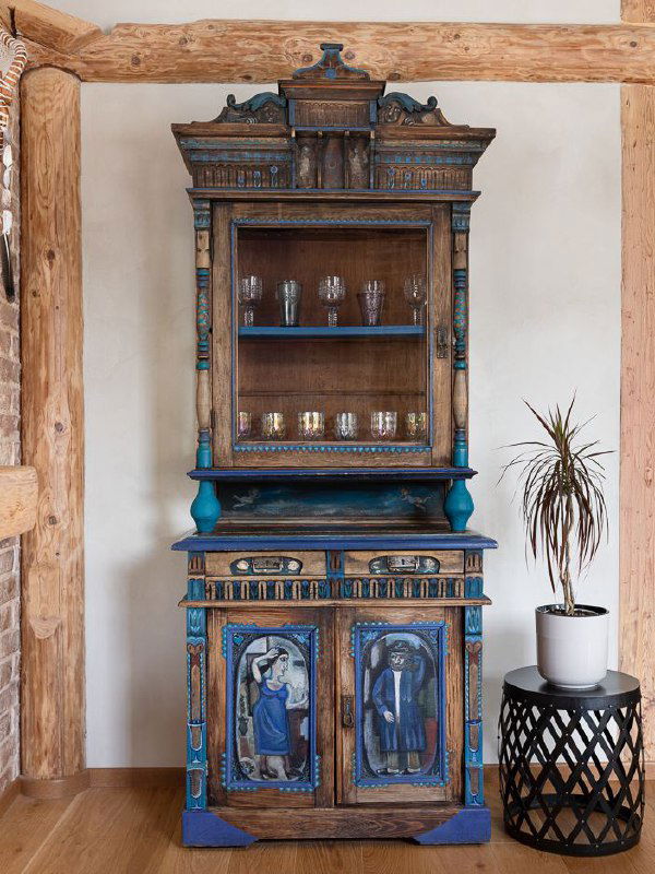 Деревянный антикварный шкаф с синим декором и витражными элементами — пример мебели с историей, предназначенной для придания интерьеру характерной текстуры.